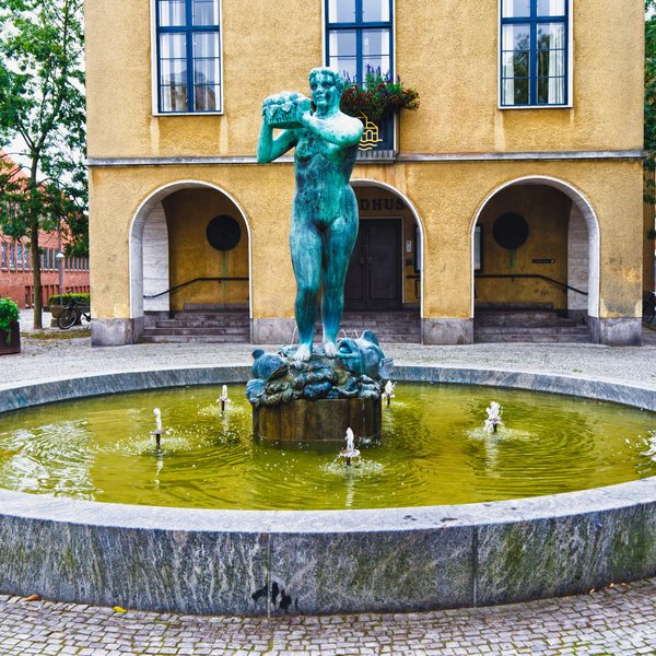 Ein Brunnen mit einer grünen, weiblichen Figur im Mittelpunkt in Sonderburg.
